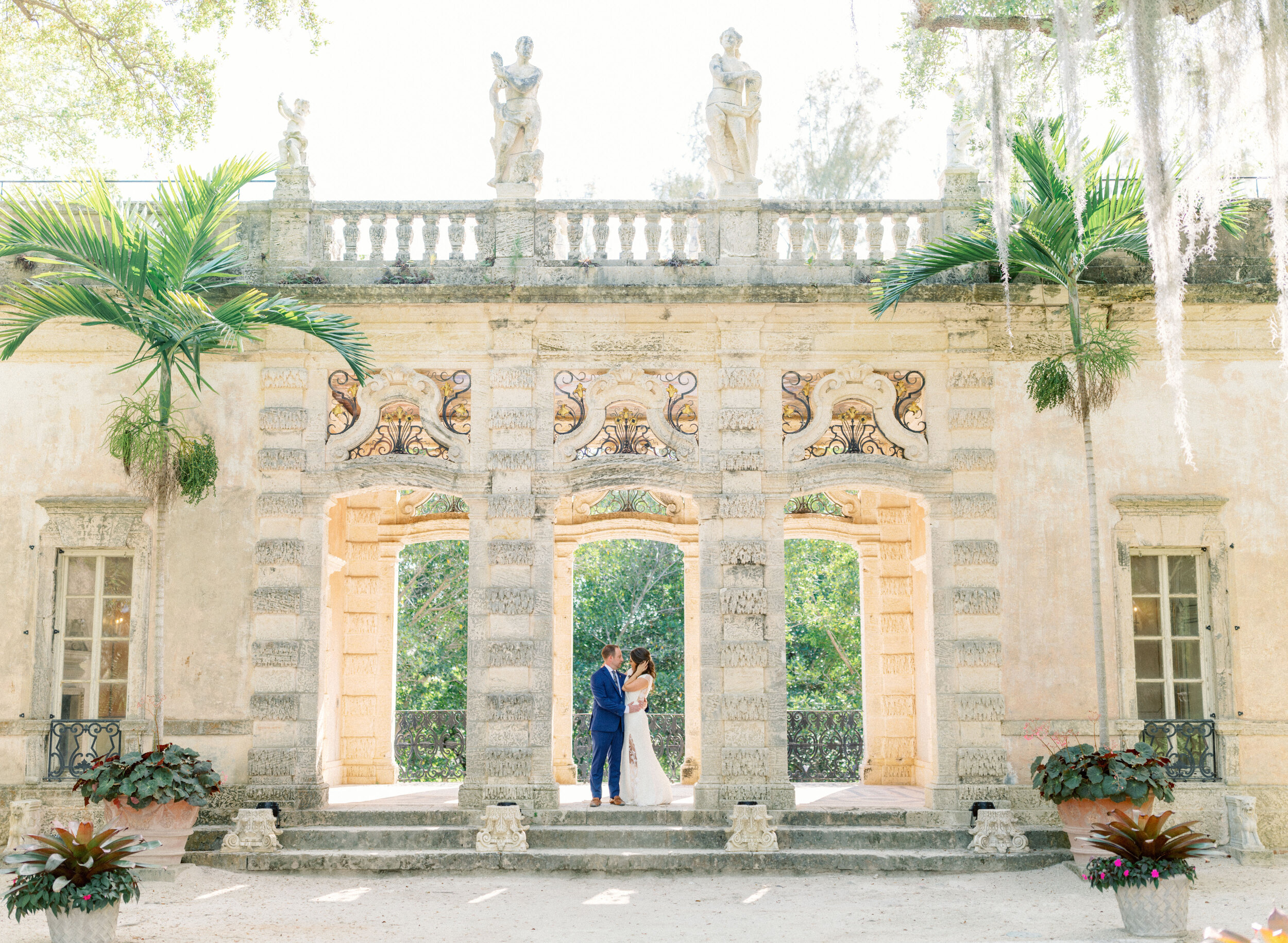 bride and groom beneath archway at Vizcaya Museum