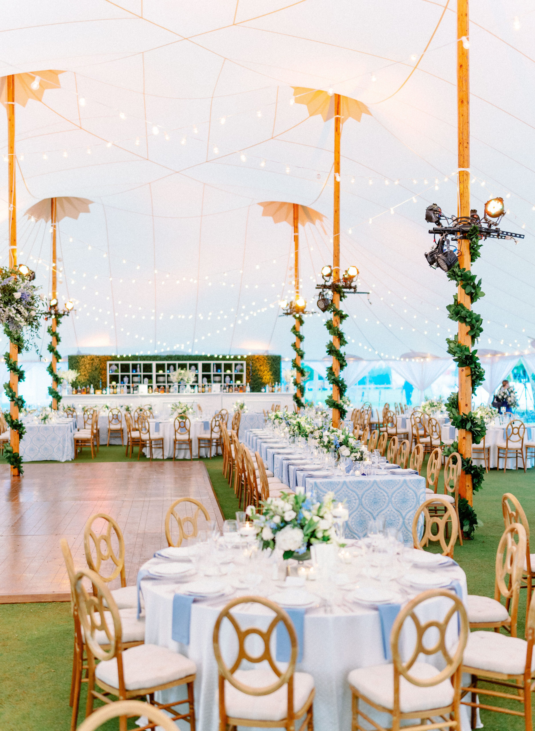tented reception at Gasparilla Inn with greenery wrapped columns and blue linen