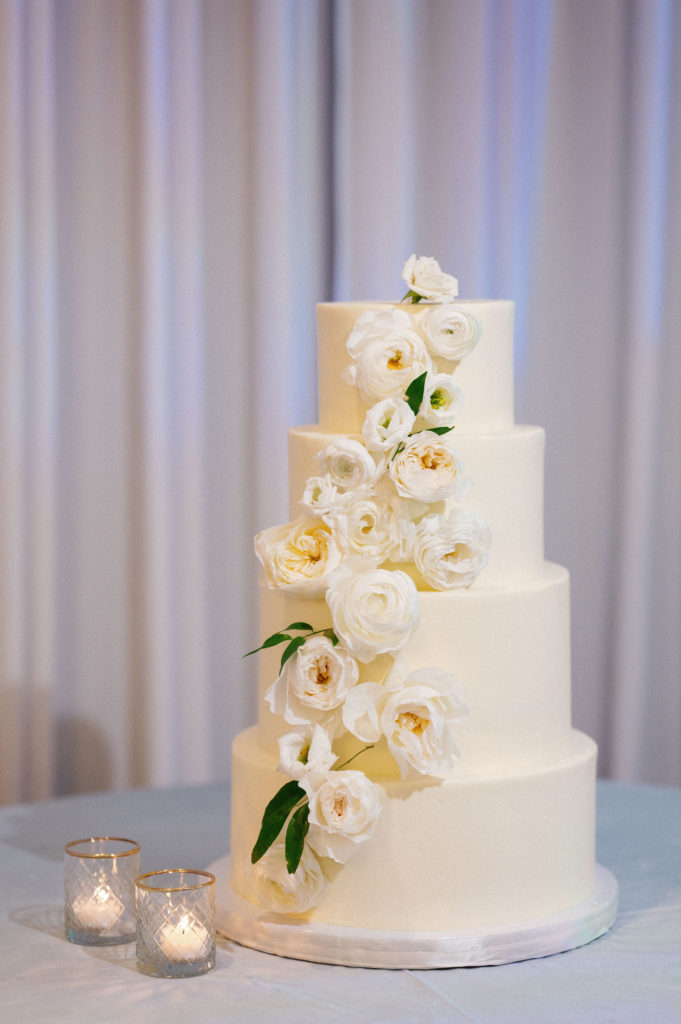 White wedding cake with white cascading flowers