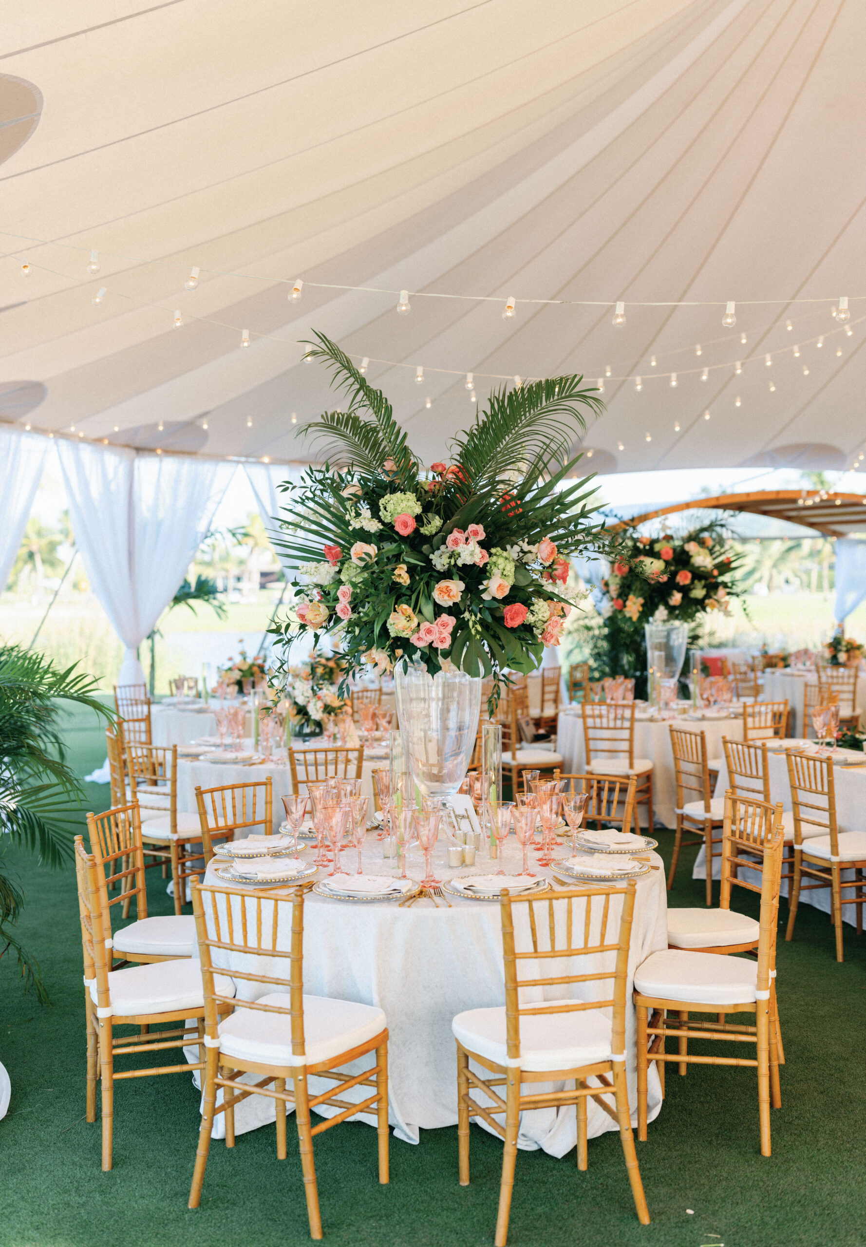 Tall, tropical theme centerpieces for tented reception at Gasparilla Club