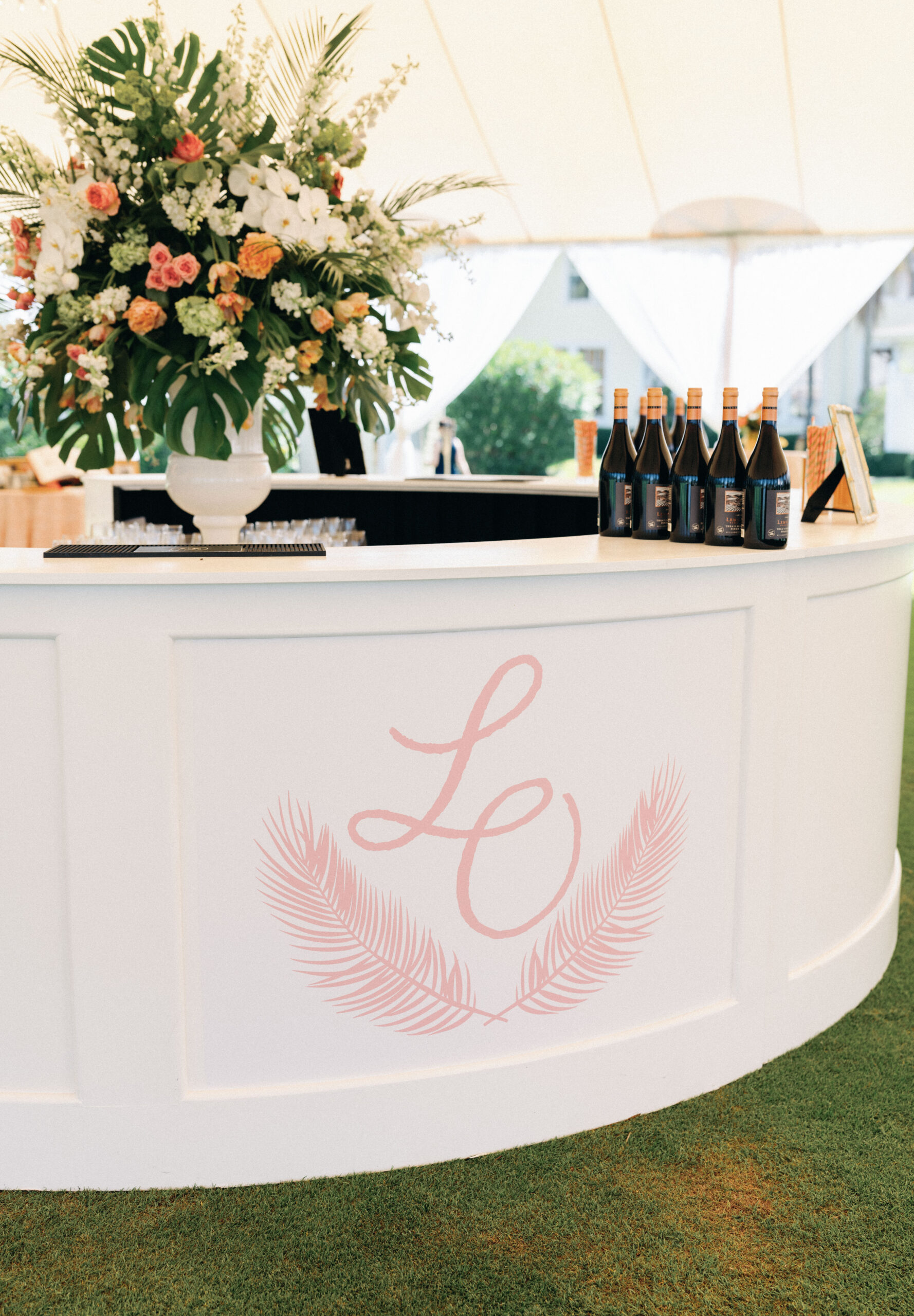 custom bar with pink feathers and script monogram