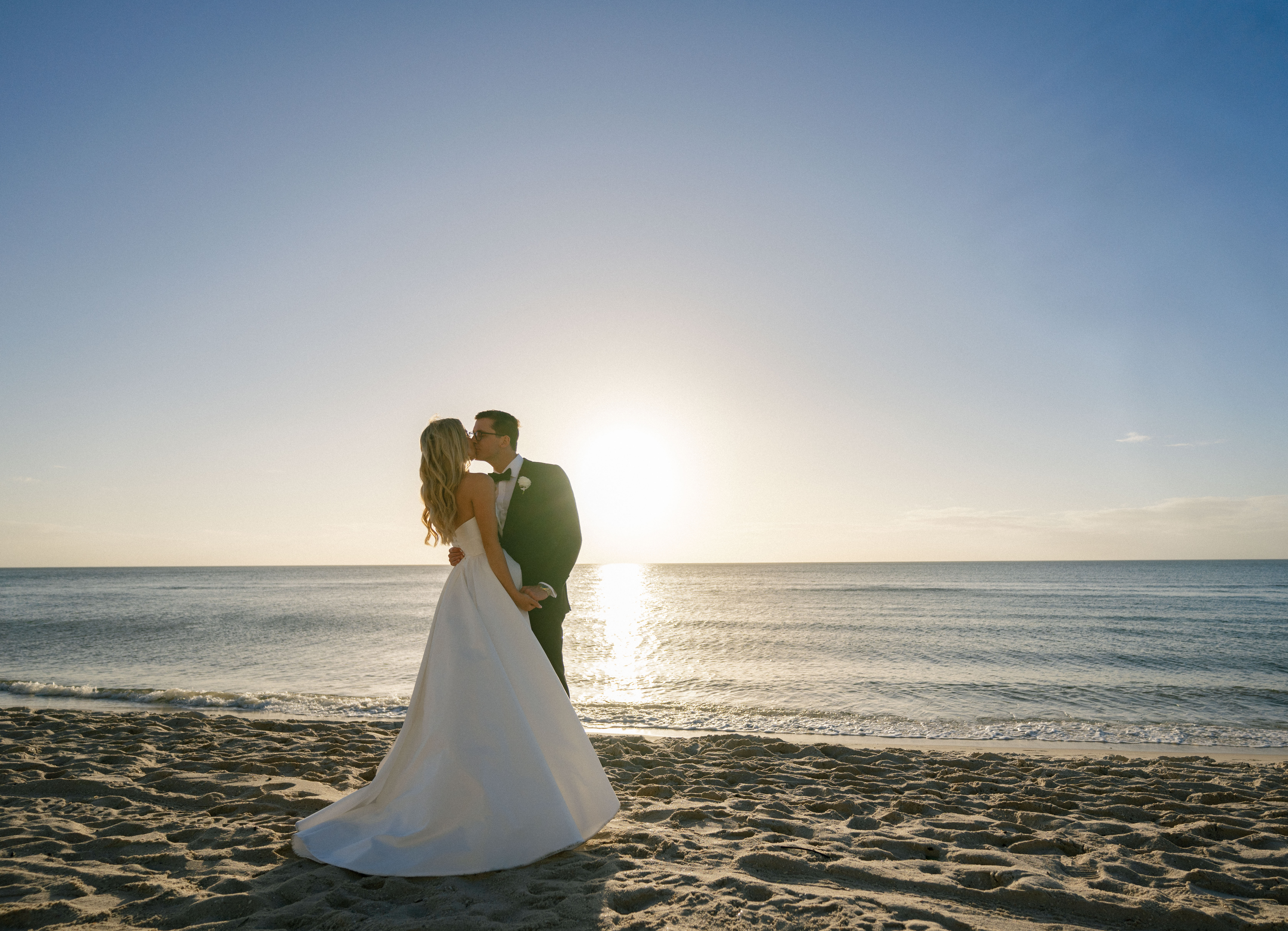 A couple shares a kiss during their Florida beach bridal portraits.