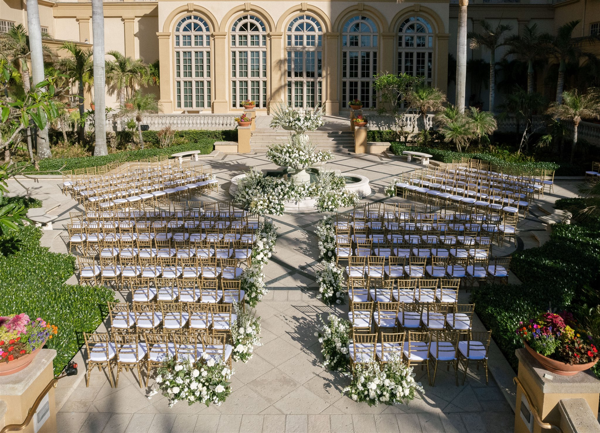 Outdoor courtyard ceremony at Ritz Carlton Naples with white florals, gold chairs