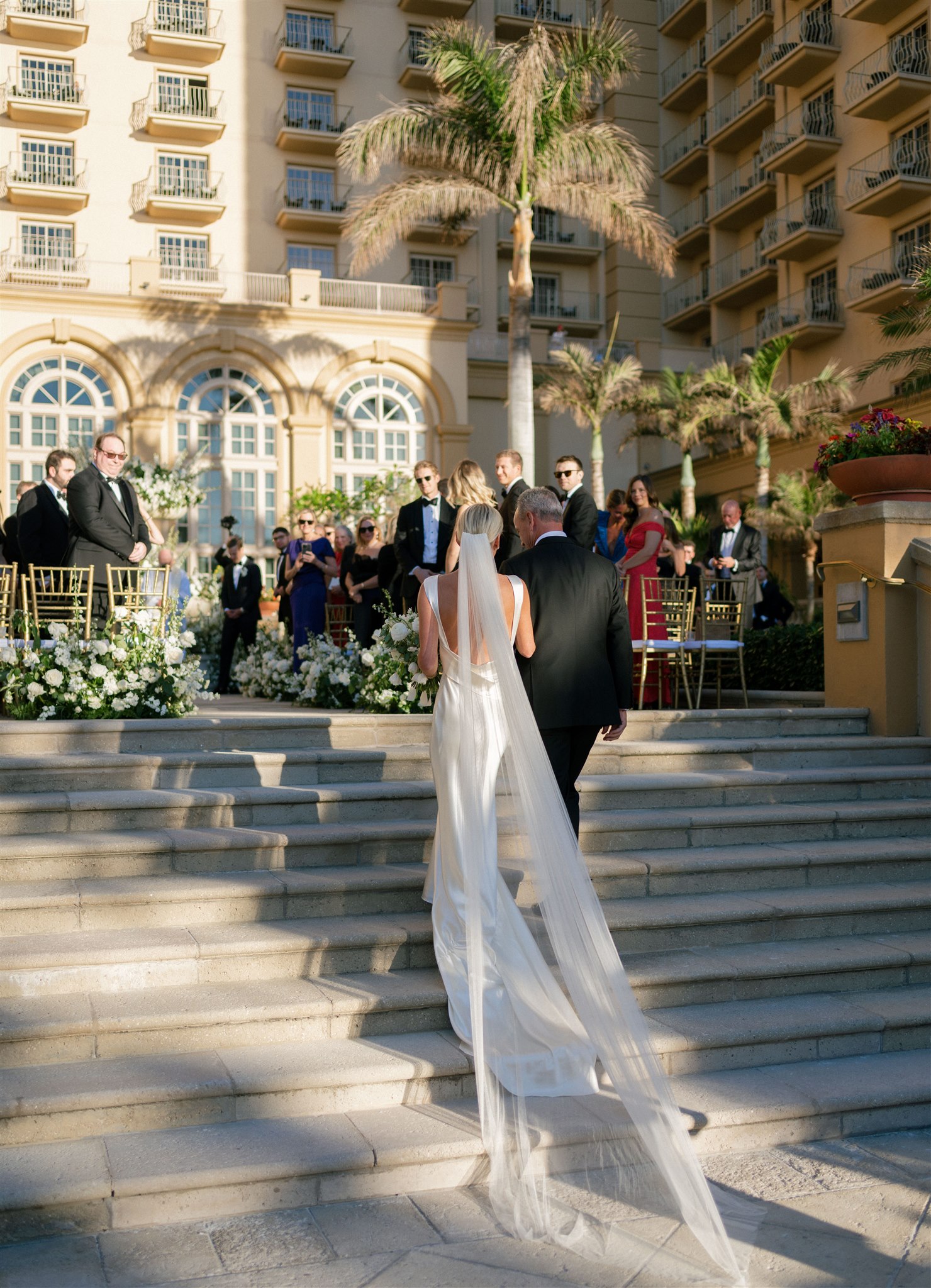 Father of the bride and bride walking up stairs for outdoor wedding at Ritz Carlton Naples