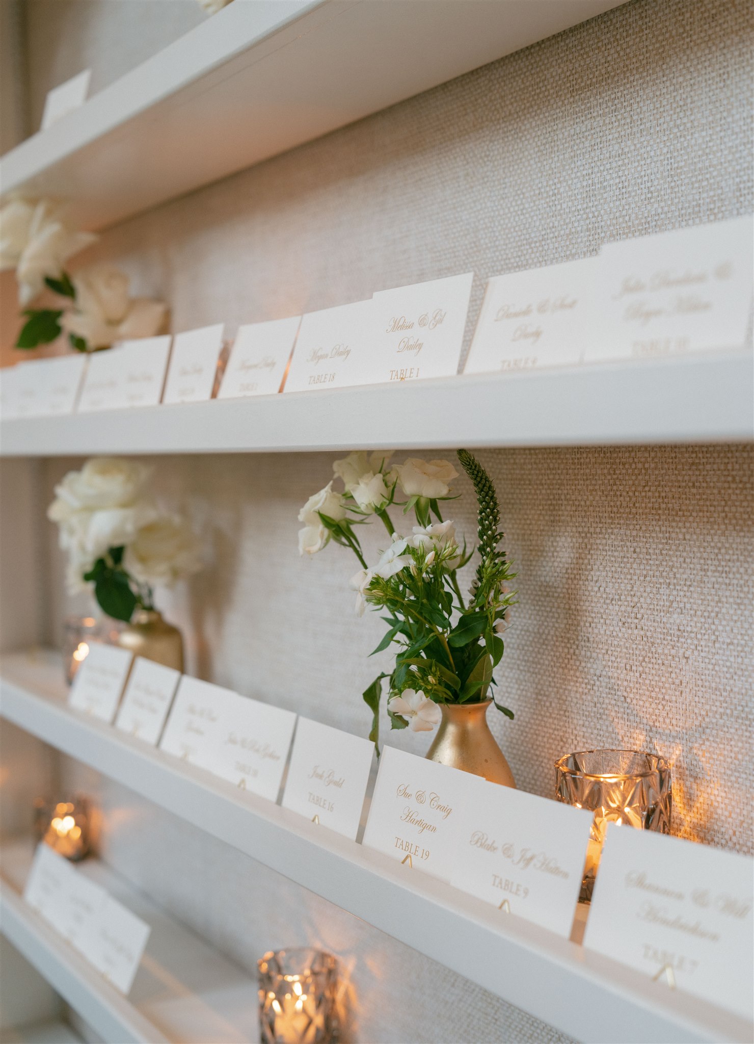 Gold and cream Escort card display with candles, bud vases