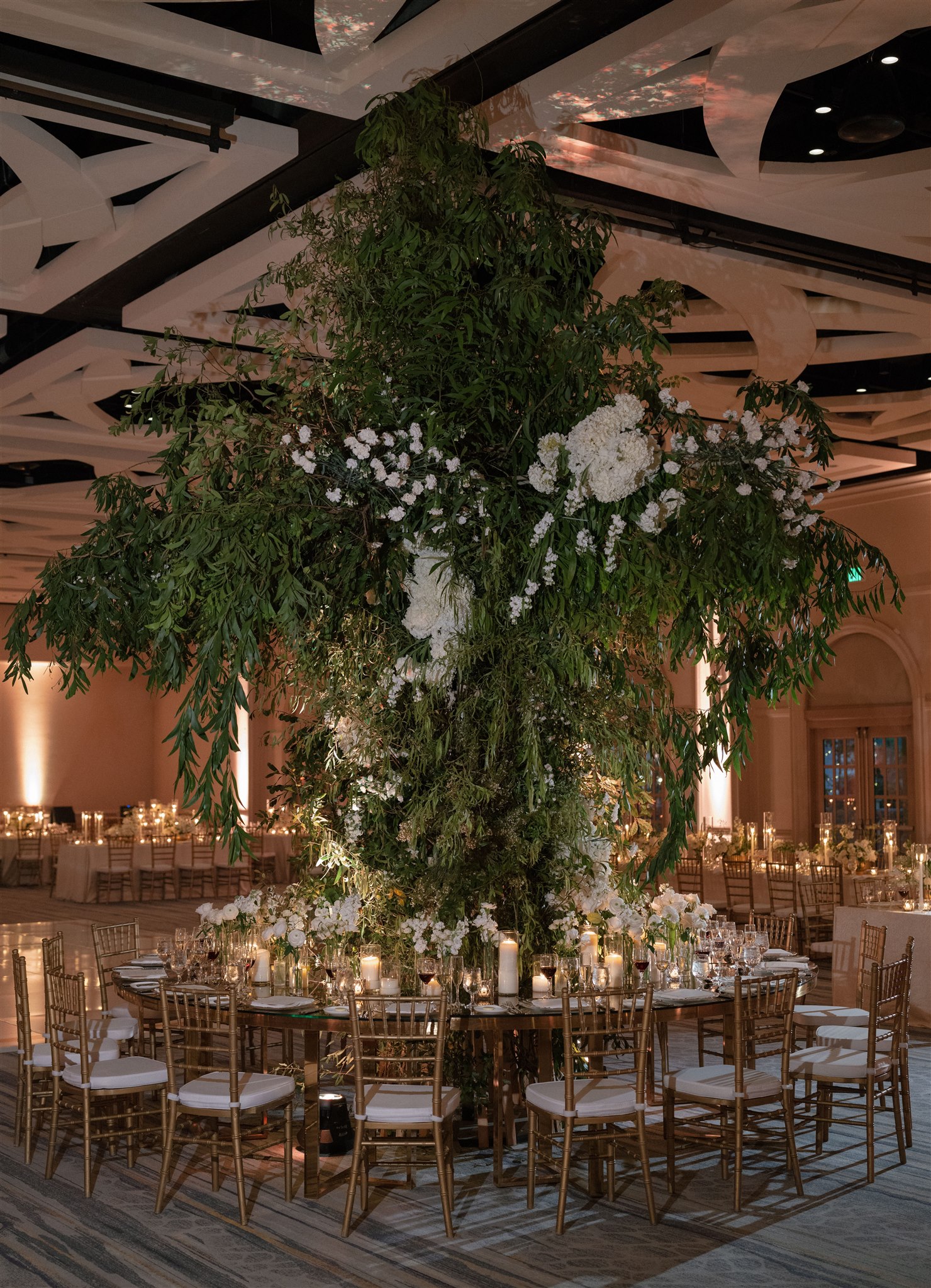 Round table with tree in the center, gold chairs