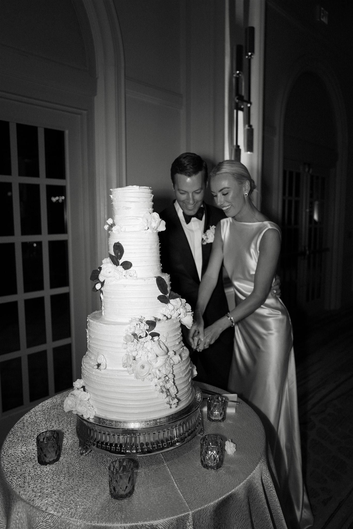 Couple cutting five-tier white wedding cake