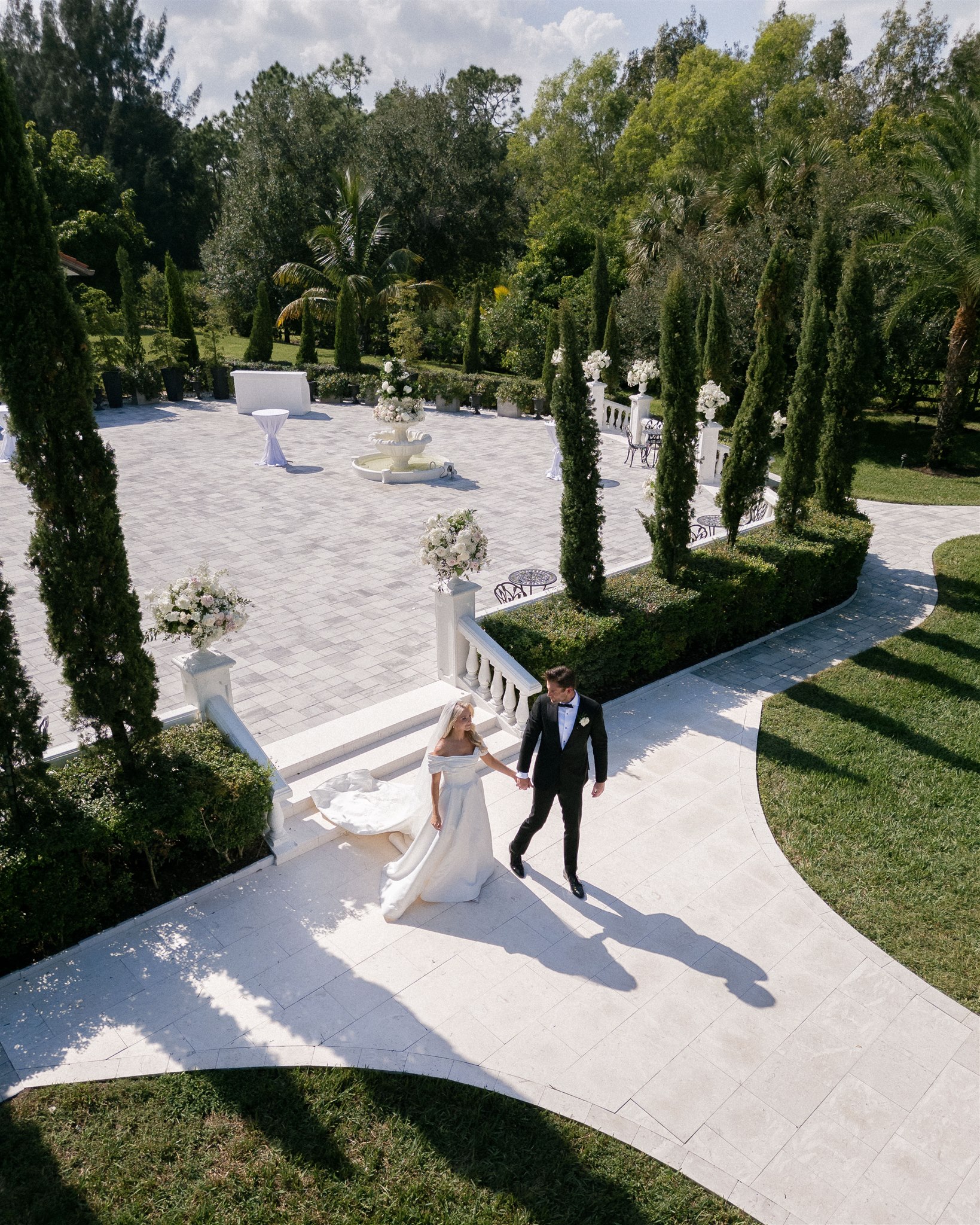 A couple walks hand in hand on their wedding day in Florida.