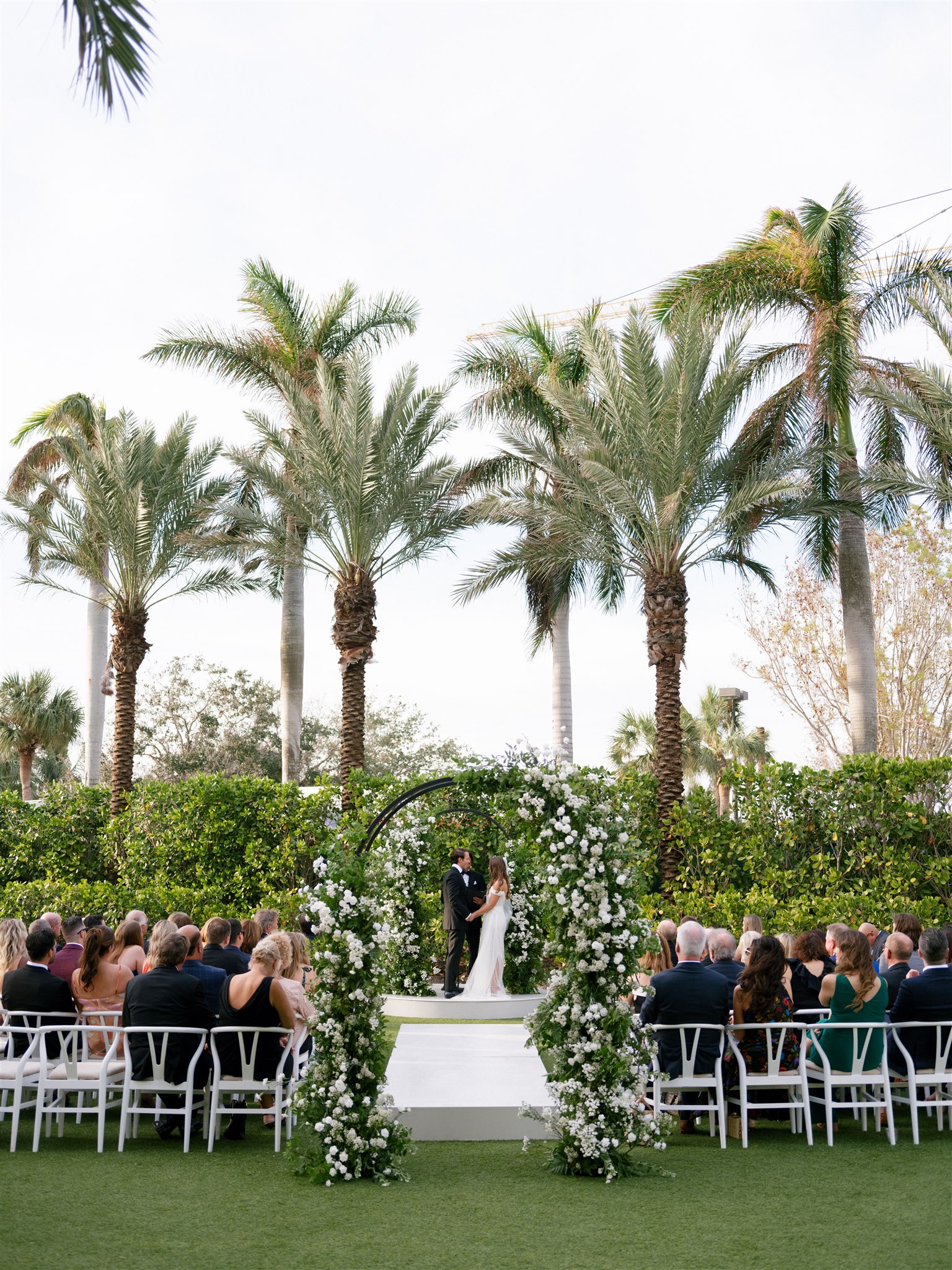 A bride and groom under their ceremony arch in Florida.
