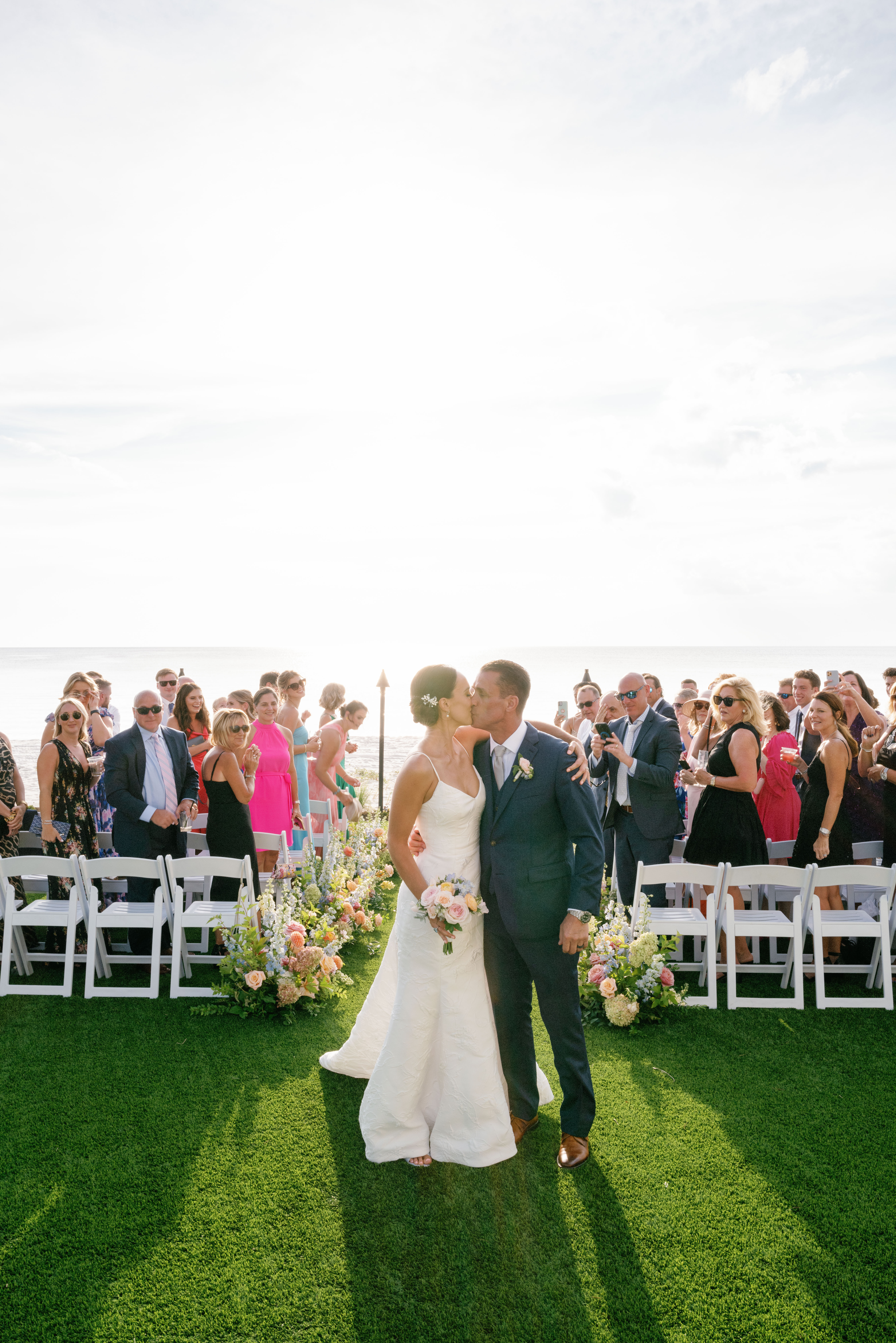 A couple share a kiss as they walk back down the aisle at their La Playa wedding.