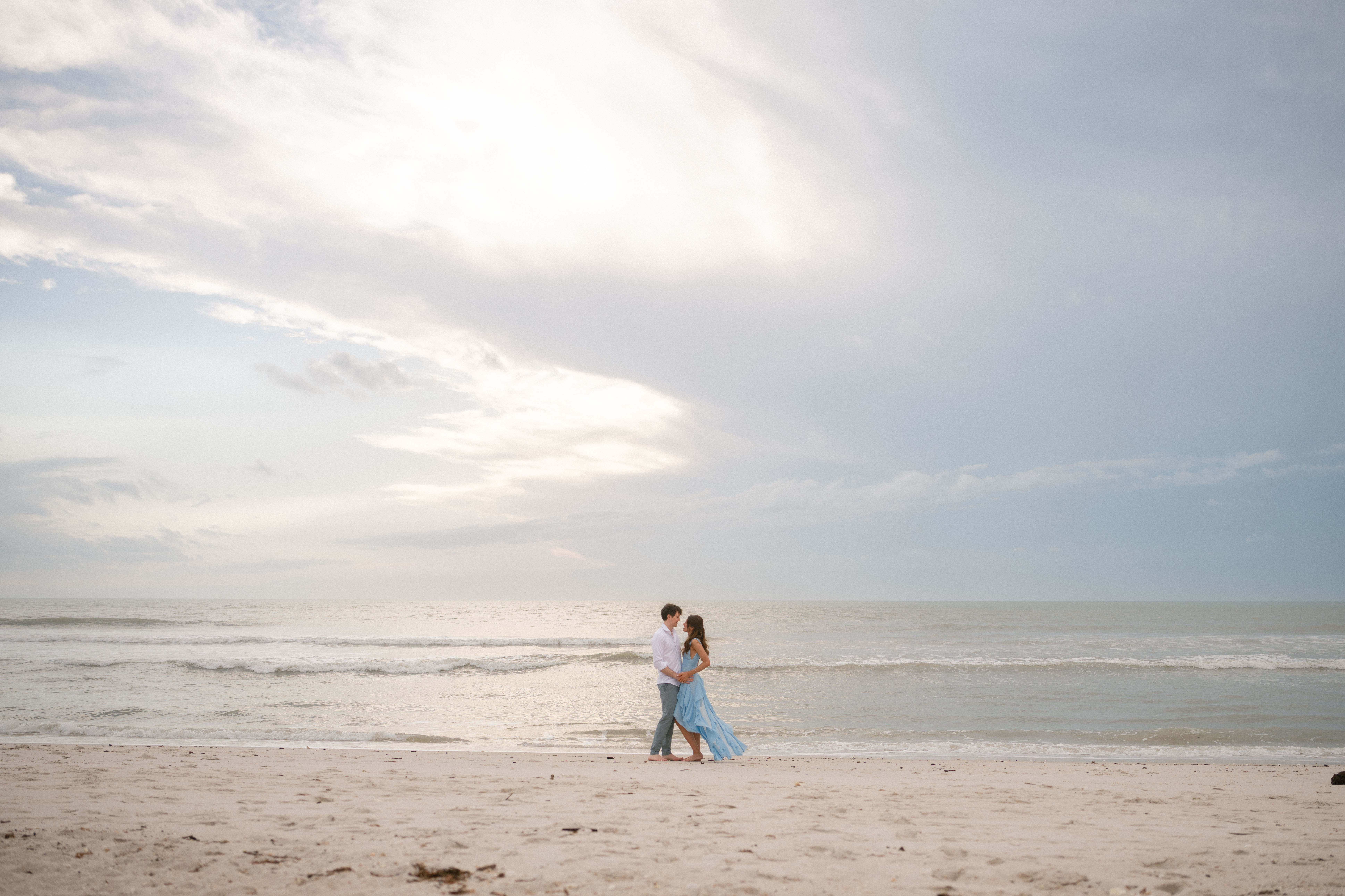 A couple posing on the Florida beach for engagement photos.