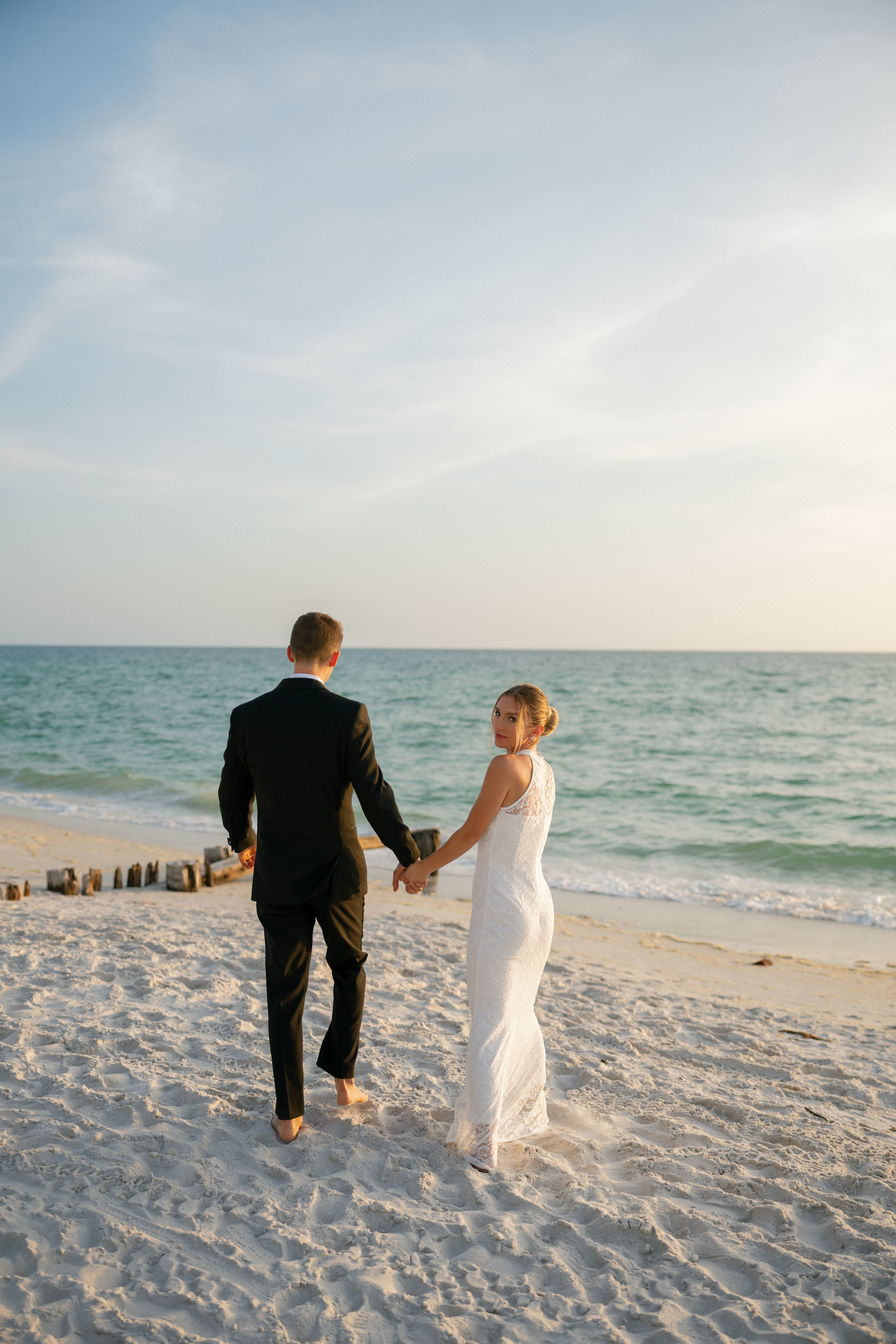 A couple poses on the beach for engagement photos in Naples, Florida.