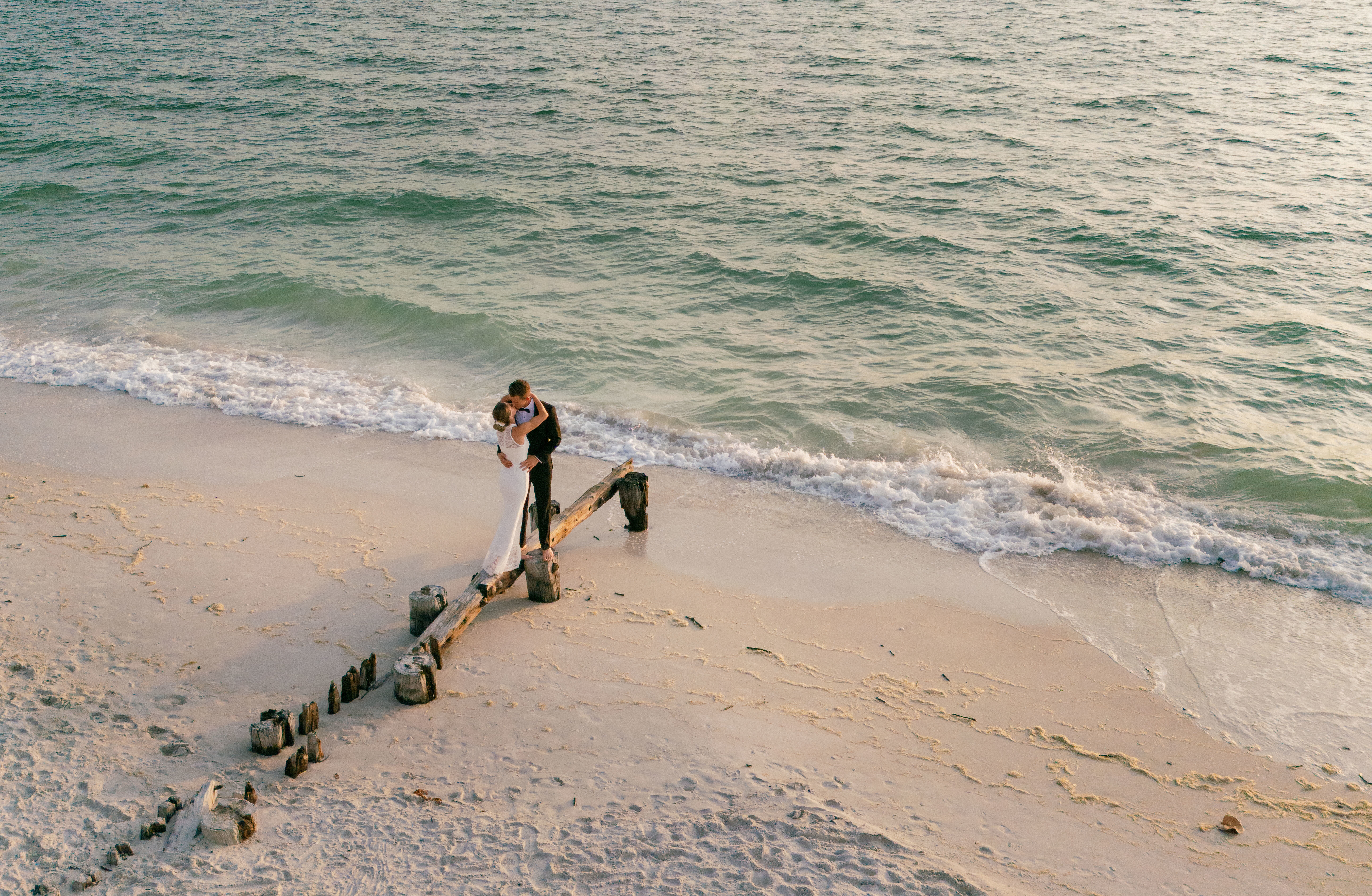 A couple posing on the beach for engagement photos in Florida.
