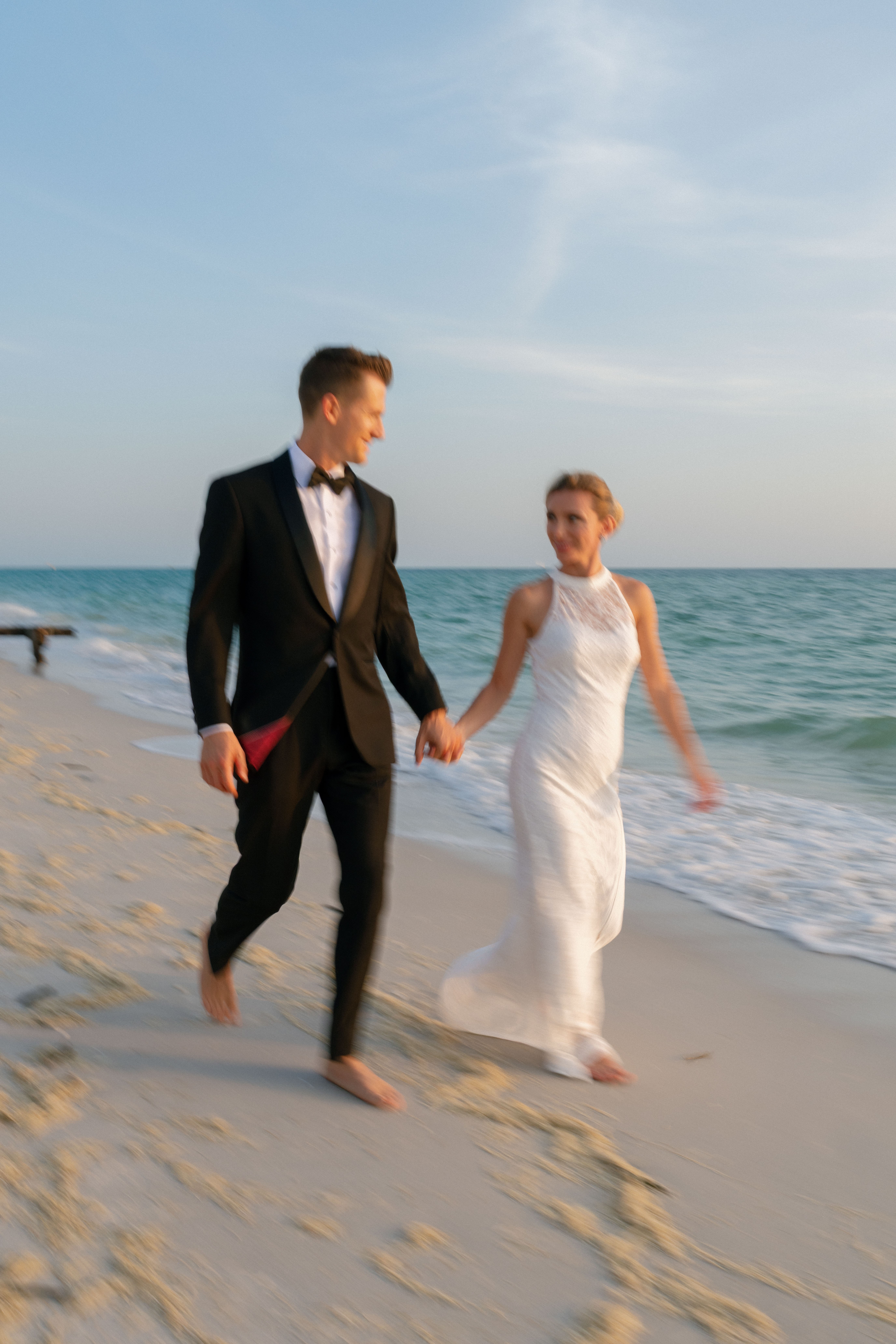 A couple poses on the beach for engagement photos in Naples, Florida.