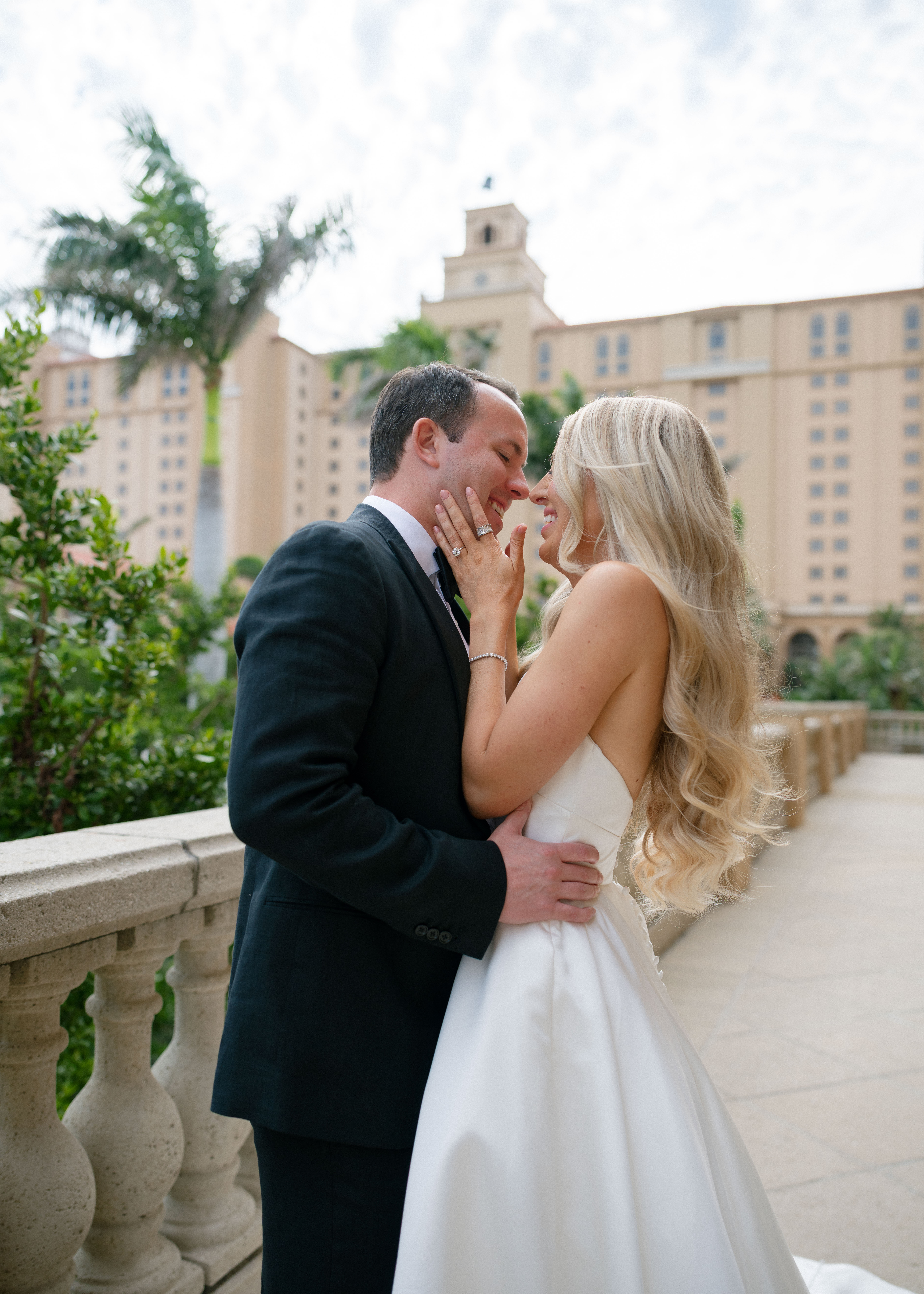 Yana & Brendan Wedding A couple sharing a laugh as they pose for bridal portraits outside of the Ritz Carlton Naples Florida.