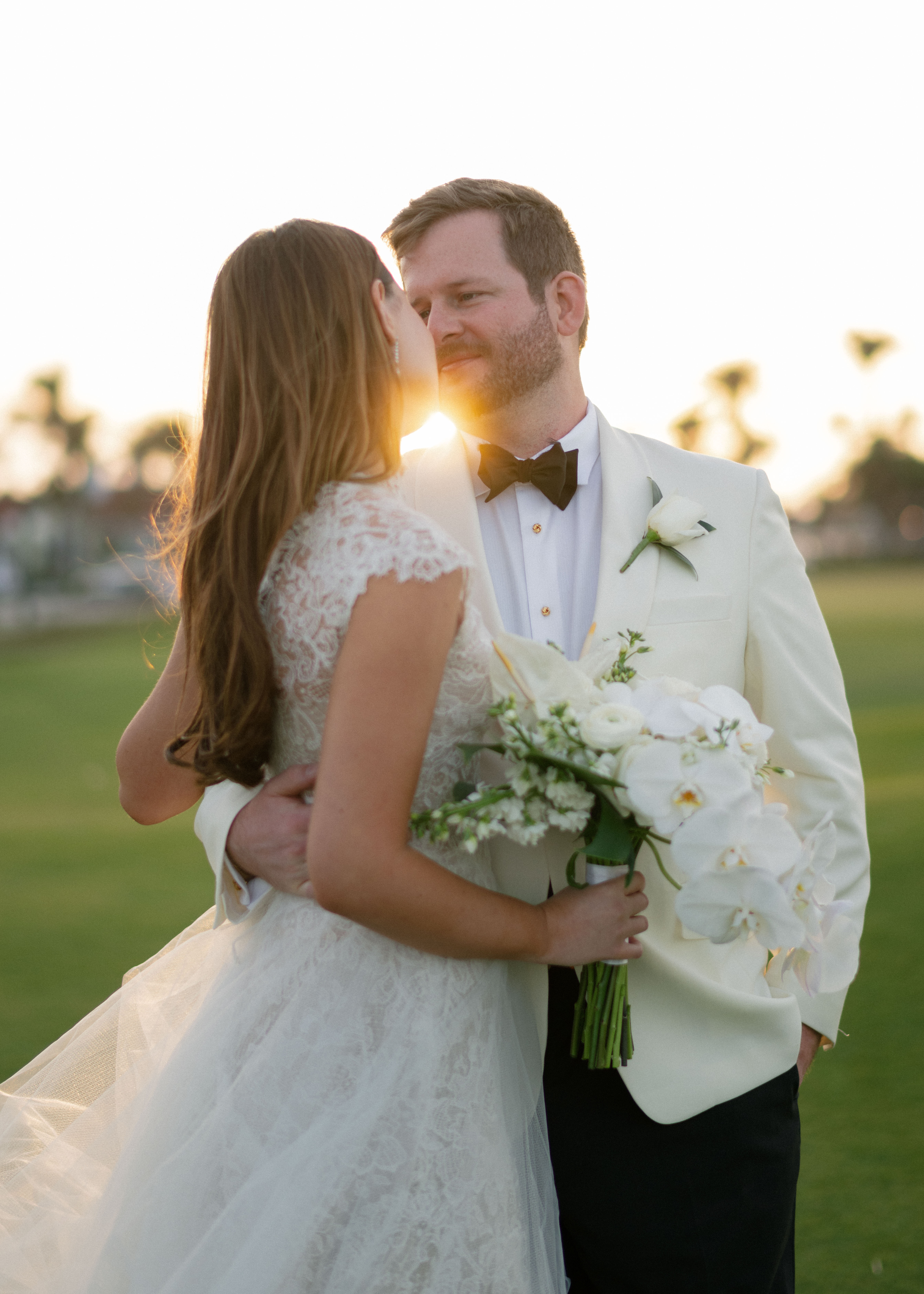 A bride and groom pose during golden hour.