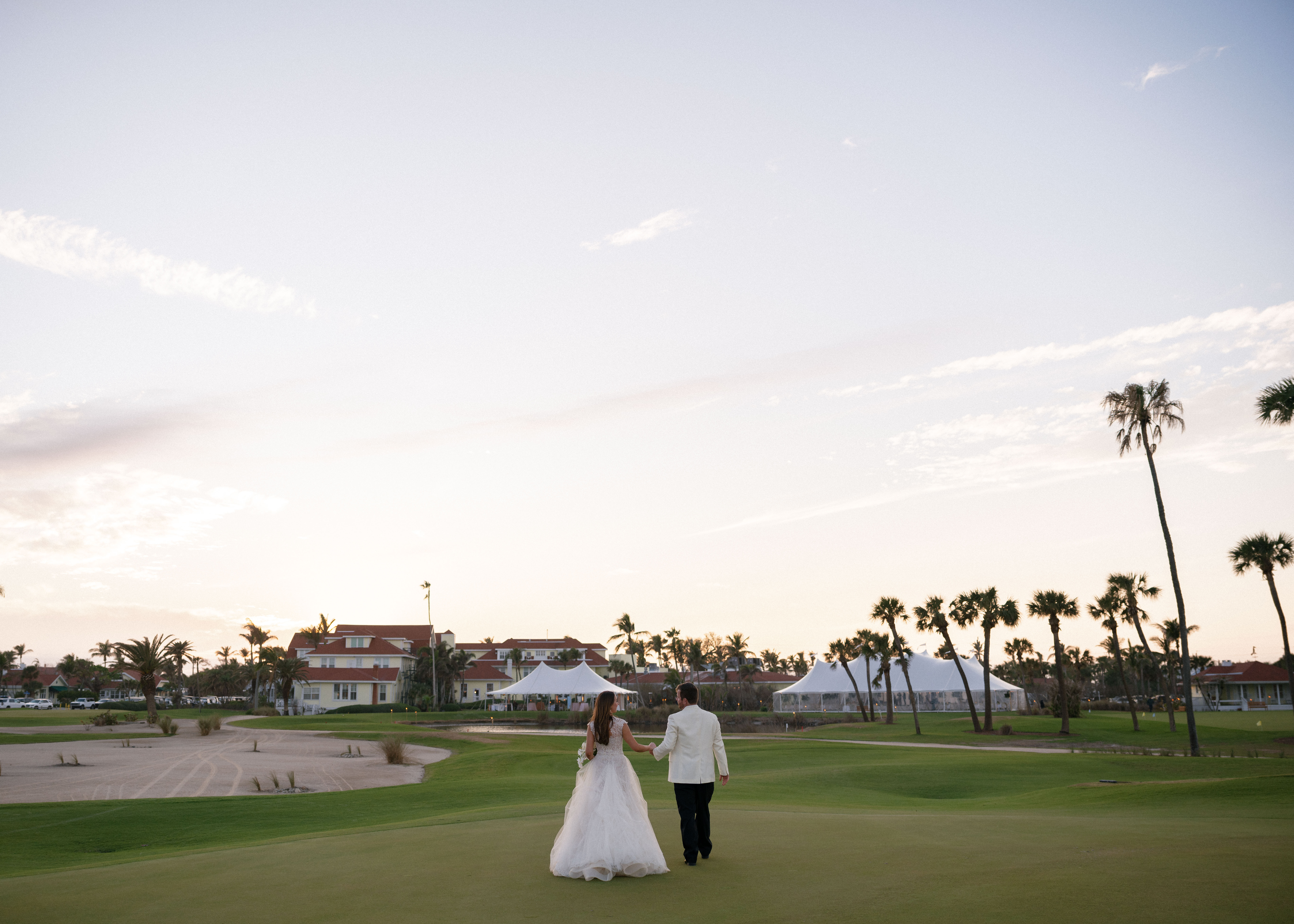 A bride and groom walking hand in hand during their Florida wedding.