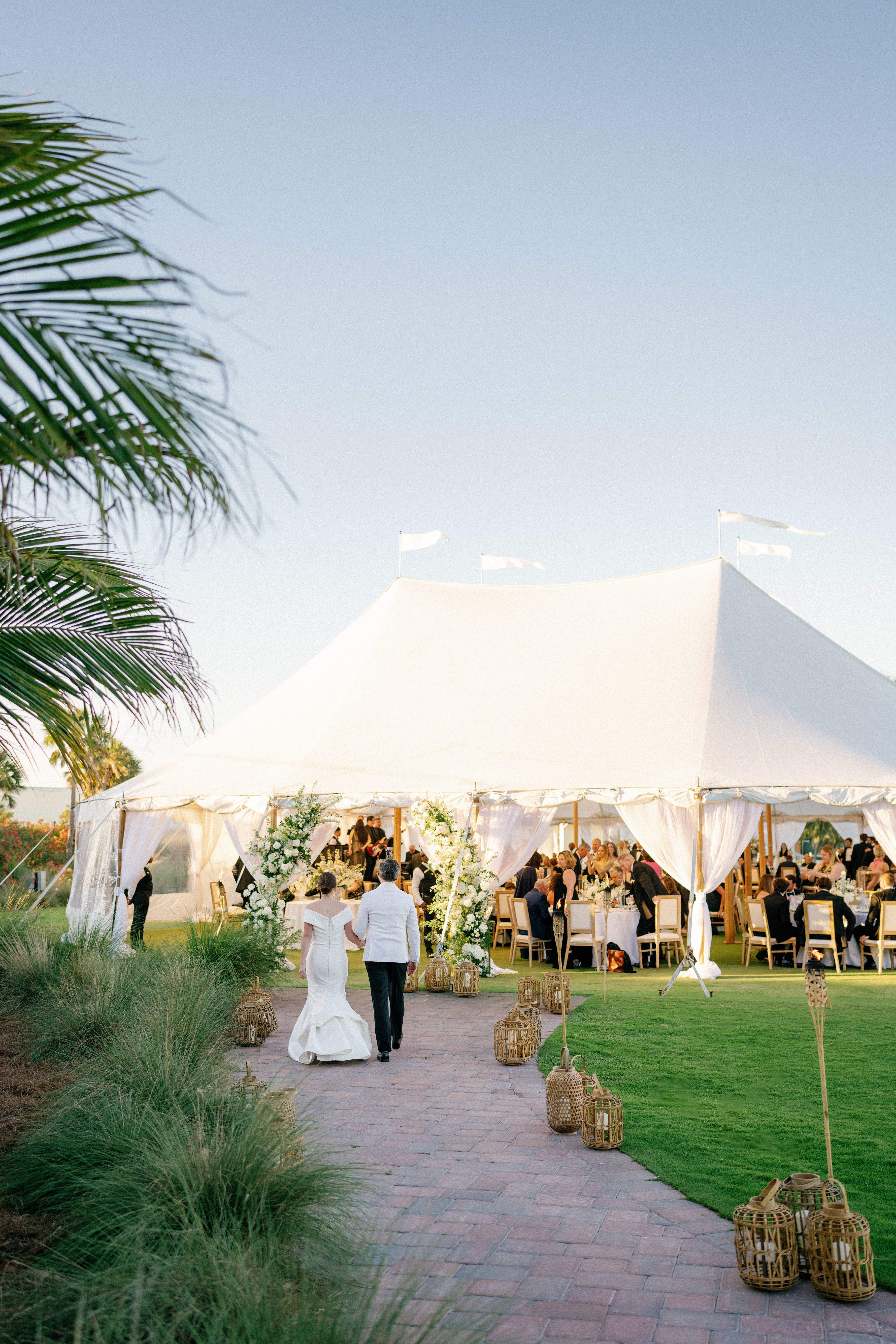 A couple walk towards their tented reception at the Gasparilla Inn in Boca Grande, Florida.
