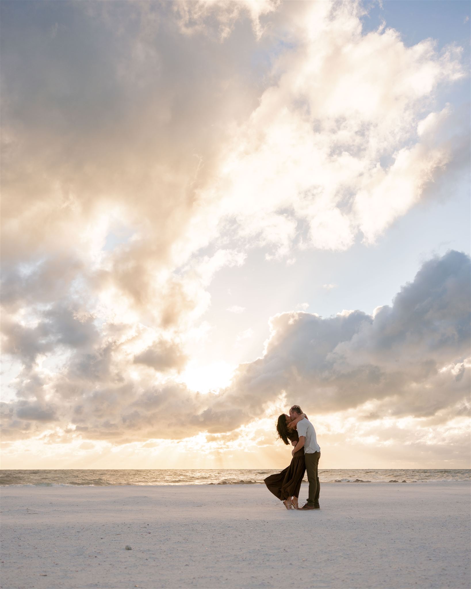 A couple pose on the beach for engagement photos in Florida.