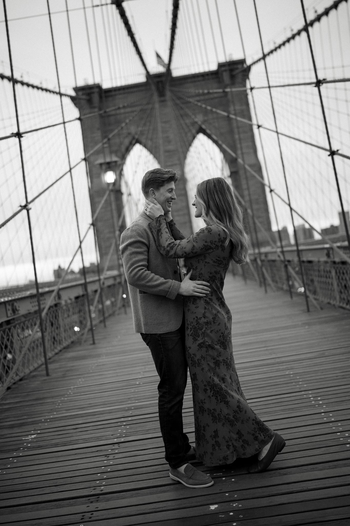 An engaged couple posing on the Brooklyn Bridge in January.