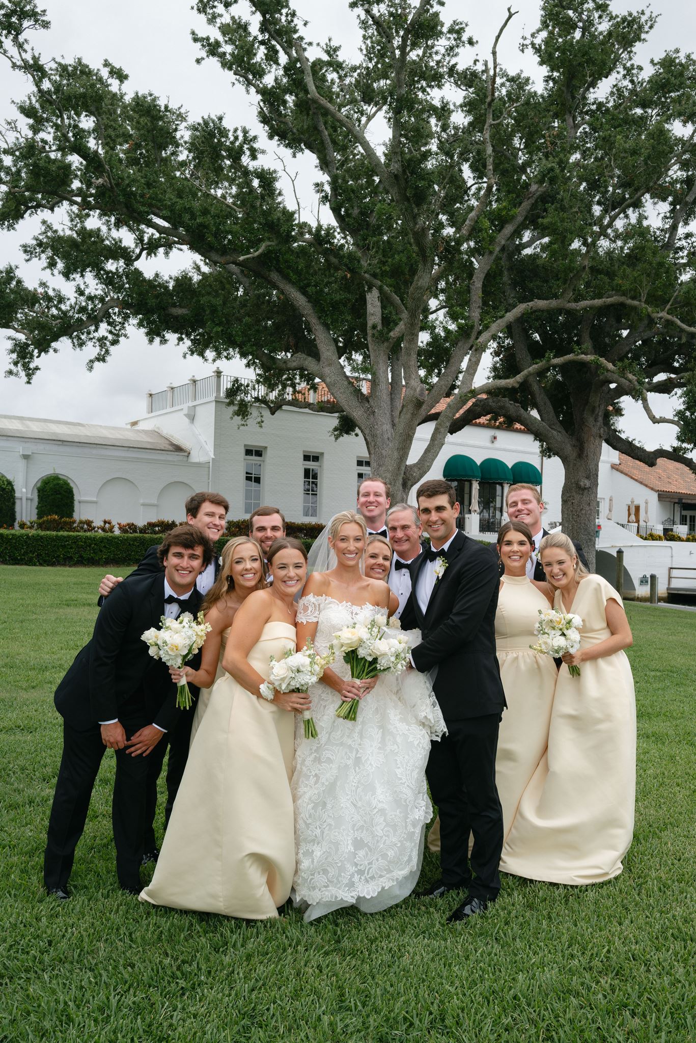 Bridal party portrait outside with yellow dresses and black tuxes.